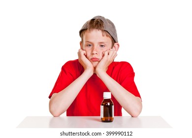 Single Pouting Boy In Red Short Sleeved Shirt And Backwards Hat With Hands On Cheeks Next To Medicine Bottle