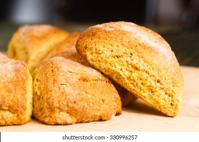 A Single Pumpkin Scone Arranged Against A Ring Of Similar Scones.