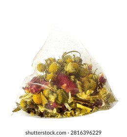 Single pyramid tea bag filled with dried flowers and herbs isolated on white background in close up studio shot