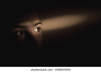 Single ray of light falling over girls eyes