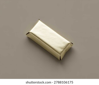 Single rectangular chocolate bar wrapped in shiny metallic gold foil packaging isolated against a solid neutral light brown studio background
