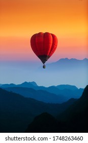 single red hot air balloons flying over blue mountains landscape 