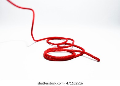 Single Red Rope Thread With Roll Up On A White Background.