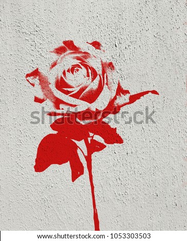 Single red rose made in graffiti style with stencil effect painted on white textured concrete wall with copy space.