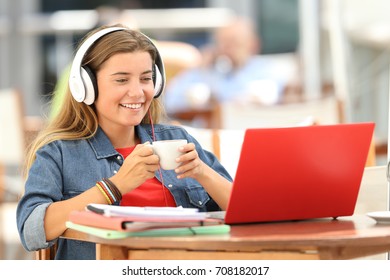 Single relaxed student watching media content in a red laptop sitting in a restaurant