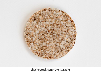 Single Rice Cake Isolated On White Background, Top View Of Puffed Wholegrain Crispbreads