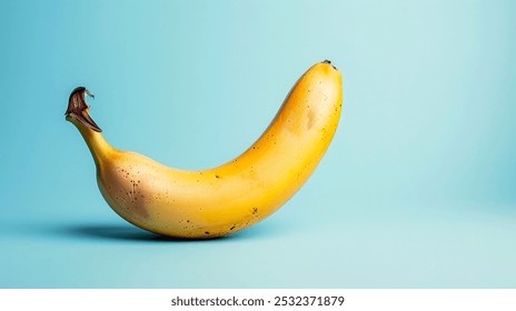 A single, ripe banana with brown spots, photographed against a bright blue background. - Powered by Shutterstock