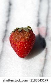 Single Rotten Strawberry On Marble