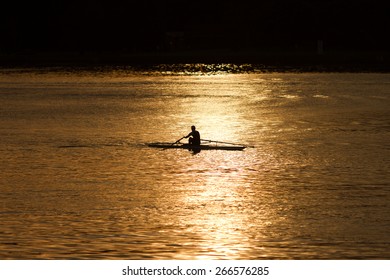 Single Rower In Silhouette At Sunrise