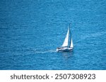 Single sailboat on blue sea