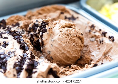 Single scoop of chocolate chip ice cream sitting in ice cream.