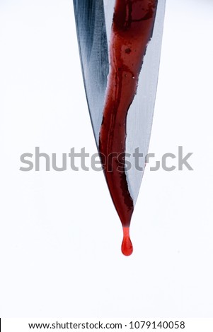 Single sharp silver knife edge in macro closeup with red blood droplets dripping off the blades edge with white background and copyspace area for murder and violence themed designs and concepts