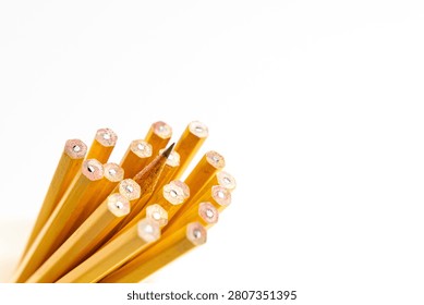 A single sharpened pencil is distinguished from a cluster of identical unsharpened pencils against a clean white background