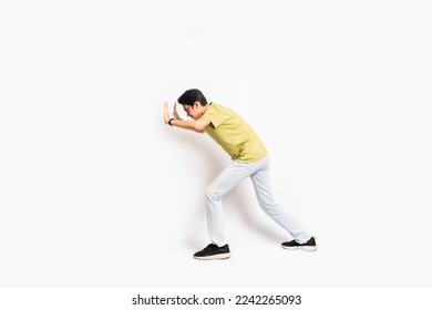 The single skinny young male tries to push something sideways. The full body of an Asian or Indonesian person. Isolated photo studio with white background. - Shutterstock ID 2242265093