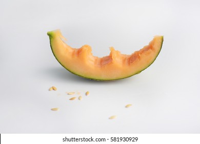 Single slice of a cantaloupe melon with a couple bites taken off it, composition isolated over the white background