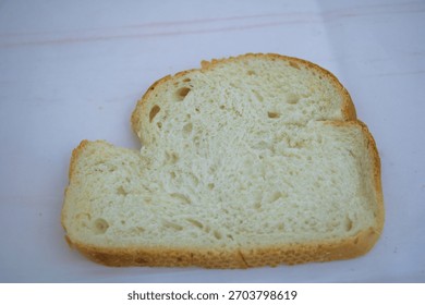 Single slice of white bread on clean background for breakfast and food preparation concept.