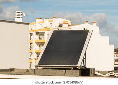 A single solar panel is installed on the rooftop of a residential building in a sunny urban setting.