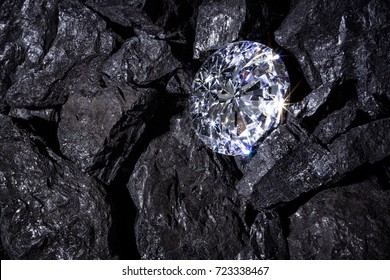 A single solitaire Diamond in amongst some pieces of coal.  - Shutterstock ID 723338467