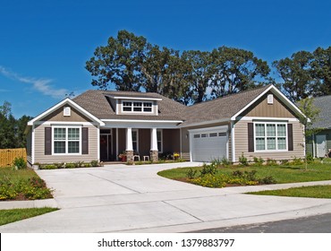 Single Story Home With Garage And Tan Siding.