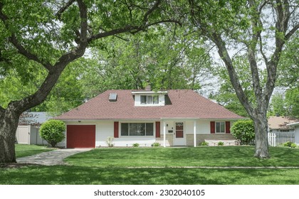 Single Story House with Red Accents Surrounded by Large Trees