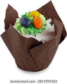 A single sweet Easter cupcake with white and green frosting swirls, topped with colorful candy eggs in a brown tulip paper liner, isolated on a white background.