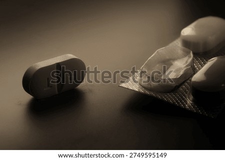 Single tablet lying beside an open medicine blister pack, emphasizing drug dependence