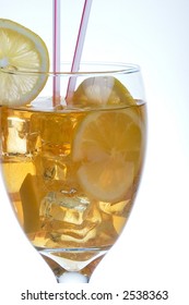 Single tall glass of iced tea full of ice cubes, slices of lemon and two straws over white background