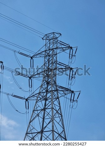 A single tangent tower, high voltage power line pylon stands in the picture. The electrical wires are connected to ceramic insulators