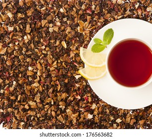 single tea cup surrounded by loose fruit tea