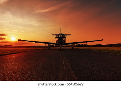 Single turboprop aircraft on evening runway at sunset-