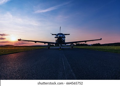 Single turboprop aircraft on evening runway after sunset-