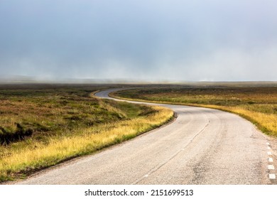 Single twisty, wavy, serpentine road with mist above in NC500, Scotland