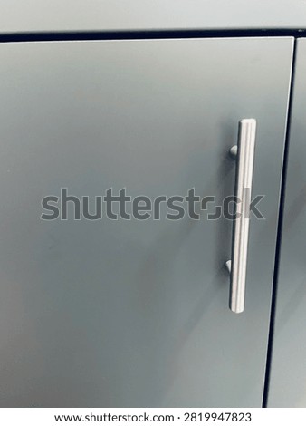 Single Vertical Bar Handle on Grey Cabinet Door, Close-Up