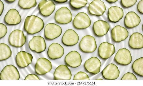 Single Water Drop Making Rings On Water Surface Over Cucumber Slices Arranged In Rows On White Background | Background For Face Care Product