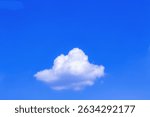 A single white cloud floating in the blue sky.
