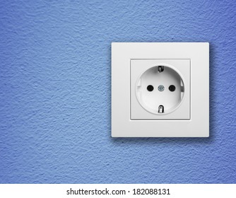 single white electric socket on blue wall 