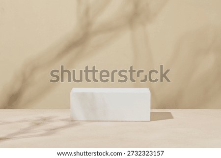 Single white rectangular podium on a warm beige pastel background, providing a clean and neutral product display scene