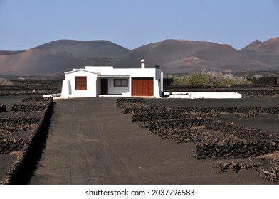 Single White Spanish Bungalow In Width Of Black Volcanic Landscape On Canary Island Lanzarote, Spain