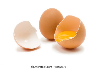 Single whole Hens Egg with cracked egg showing yolk isolated against white background