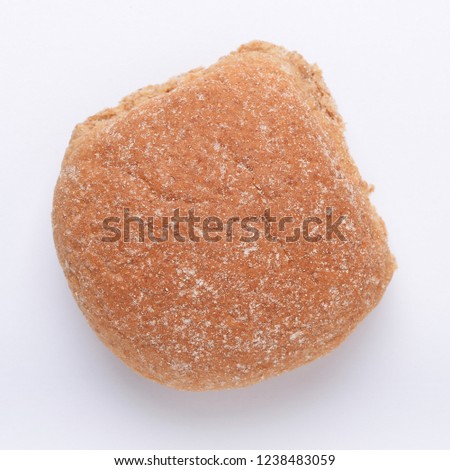Single wholewheat breadcake bap on white background from above
