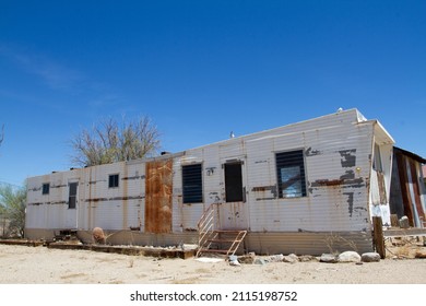 Single Wide Mobile Home Trailer Left In Disrepair Rusting Steel Exterior, Busted Windows, Left Long Abandoned By Resident As Local Economy Collapse Destroyed Mining Industry Work 