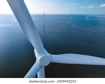 A single wind turbine stands tall in the middle of the vast ocean, harnessing the power of the wind to generate renewable energy. close up of windmill turbine at sea in the Netherlands - Powered by Shutterstock