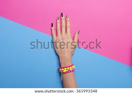 Single woman hand, wearing jewelry, in various background colors. Graphic look, solid bold colors, close up shot.