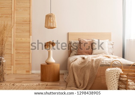 Single wooden bed with natural decoration in beige colour in kid room