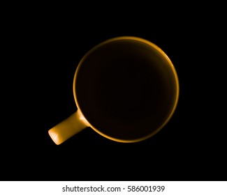 Single yellow cup. Illuminated upper circuit. View from above. Isolated on black. Copy space to add your text.