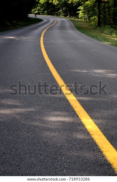 Single\
Yellow Line on the Road with Cyclist\
Silhouette