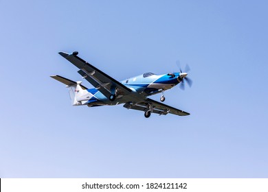 Single-engine blue airplane flying on a sunny day in the blue sky. The plane rises after takeoff.