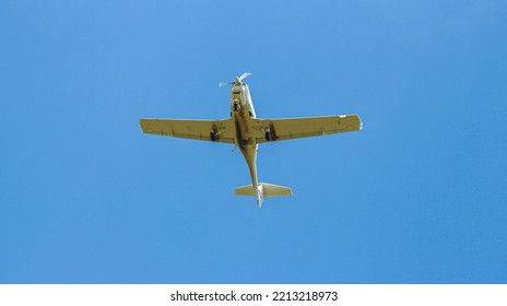 A single-engine plane is flying in the sky. A light-engine plane in the blue sky.