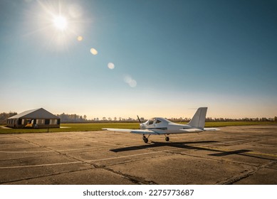 Single-engine small propeller plane on the airfield under sunlight