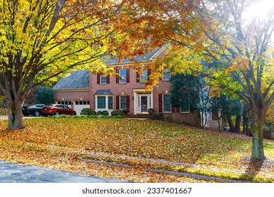 Single-family brick country house with yellow trees in the frontyard. Autumn landscape in the rays of the evening sun. - Shutterstock ID 2337401667